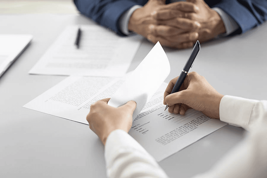 Hands signing a document